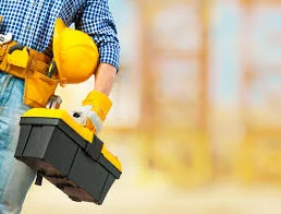 Technician carrying a toolbox and hard hat